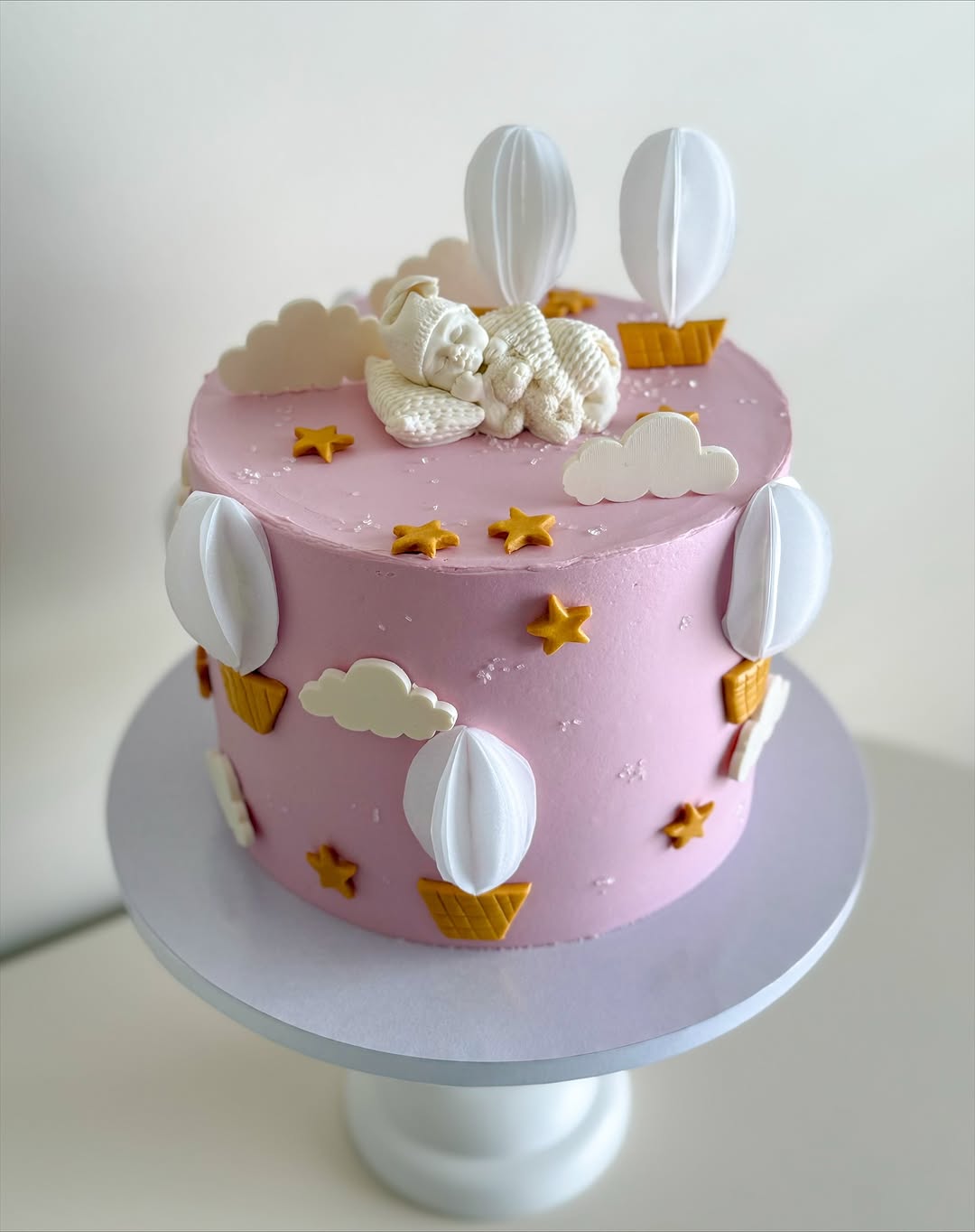 pink hot air balloon baby shower cake with clouds and stars